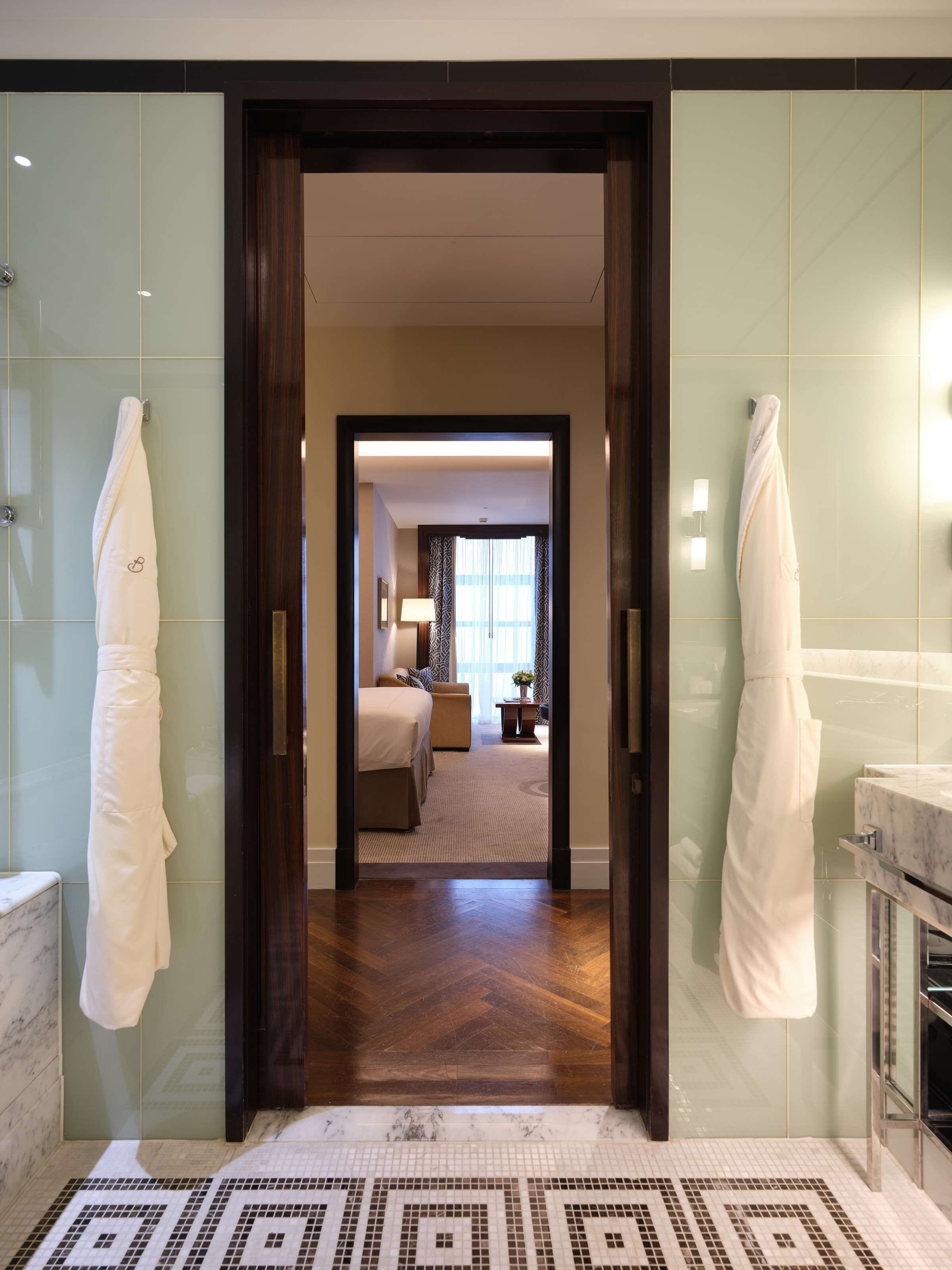 deluxe junior suite | bathroom | rainfall showerhead, designer toiletries, hair dryer, bathrobes