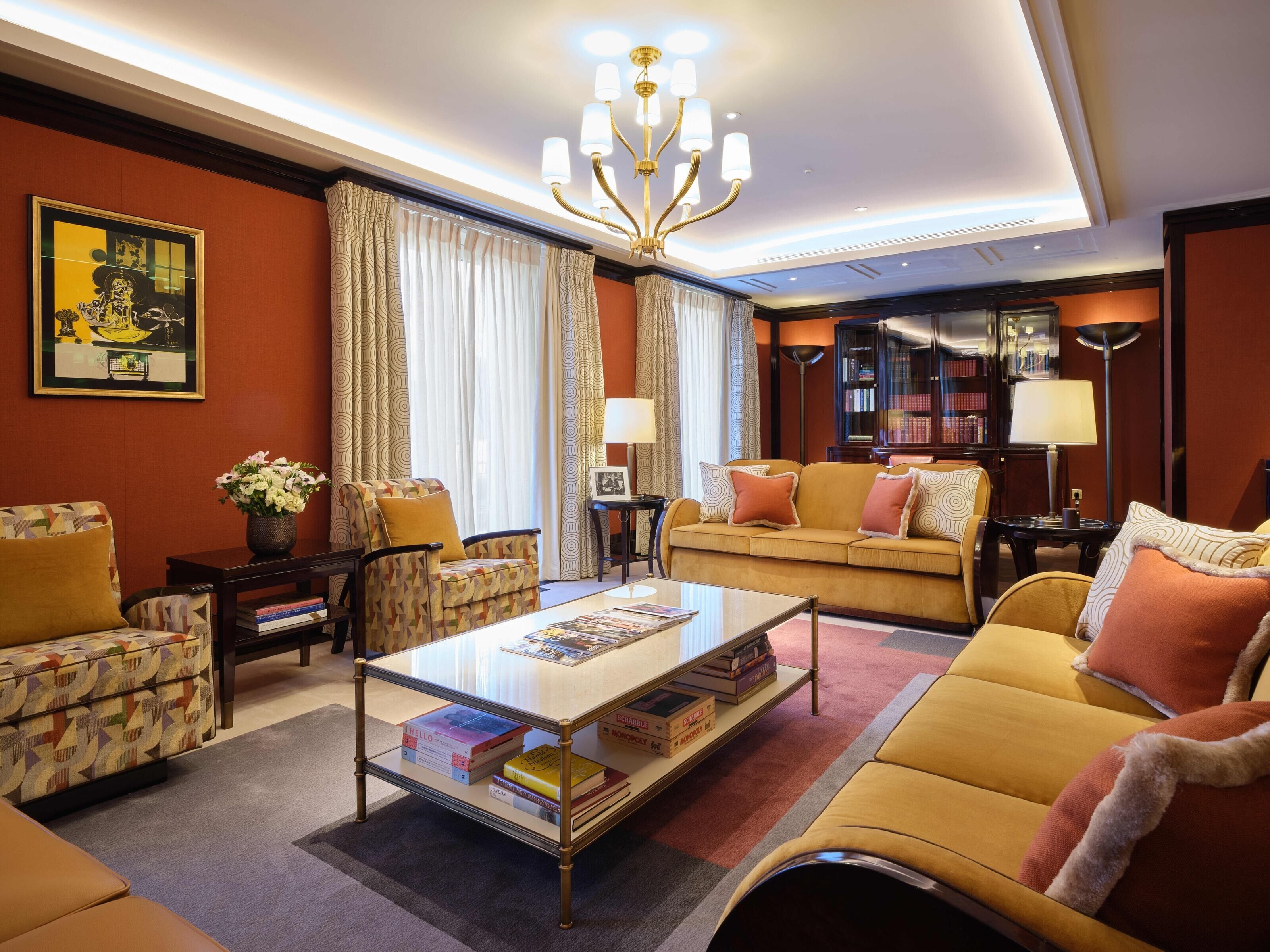 A well-lit living room with a sofa, armchairs, a coffee table, and a bookshelf.