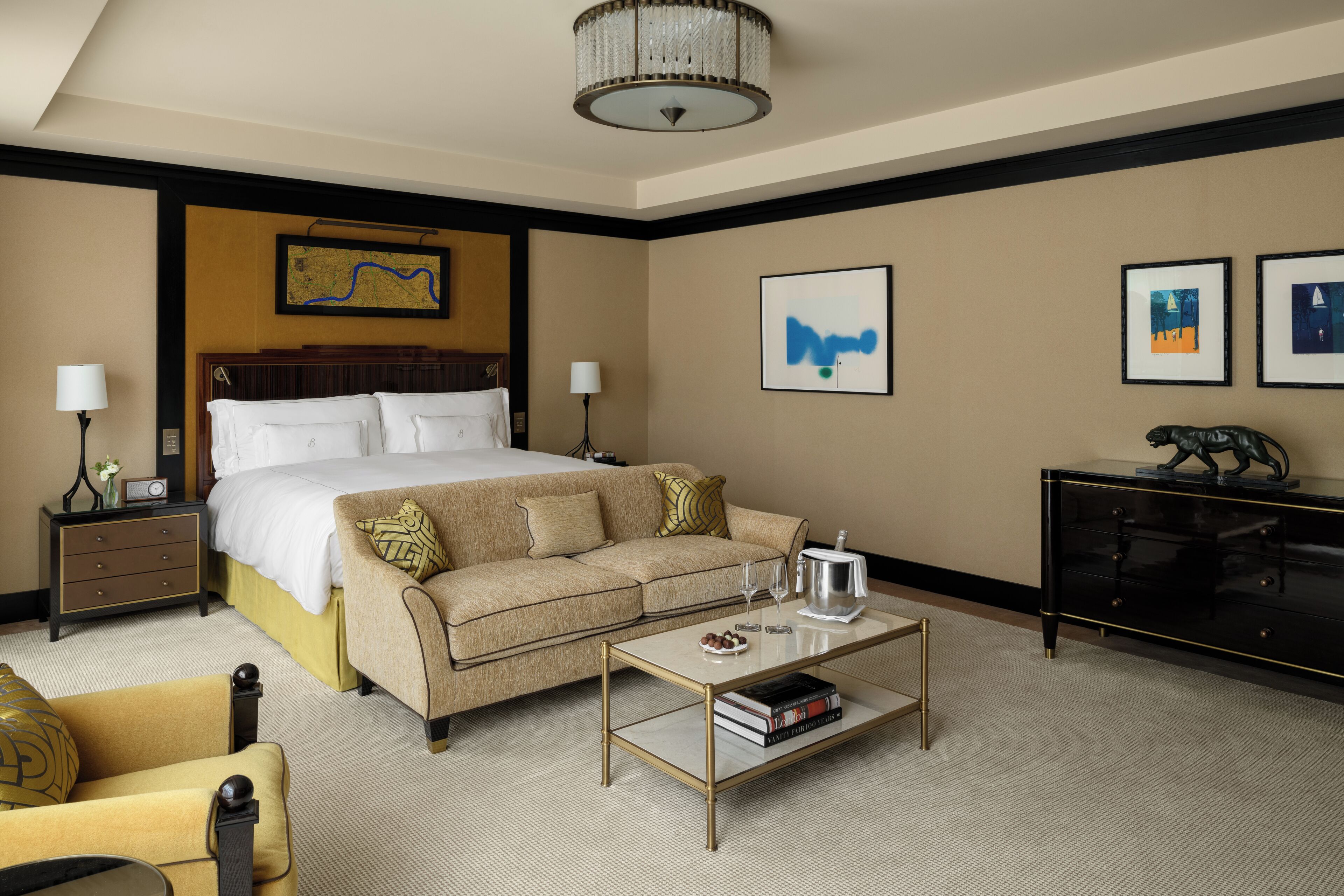 A hotel room with a bed, a sofa, a coffee table, a nightstand, and a dresser.