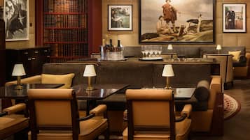 Une bibliothèque avec des étagères, un canapé et un tableau.