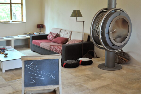 A cozy living room with a sofa, a standing lamp, and a chalkboard sign that reads "Welcome". - Une Campagne en Provence (Bras)