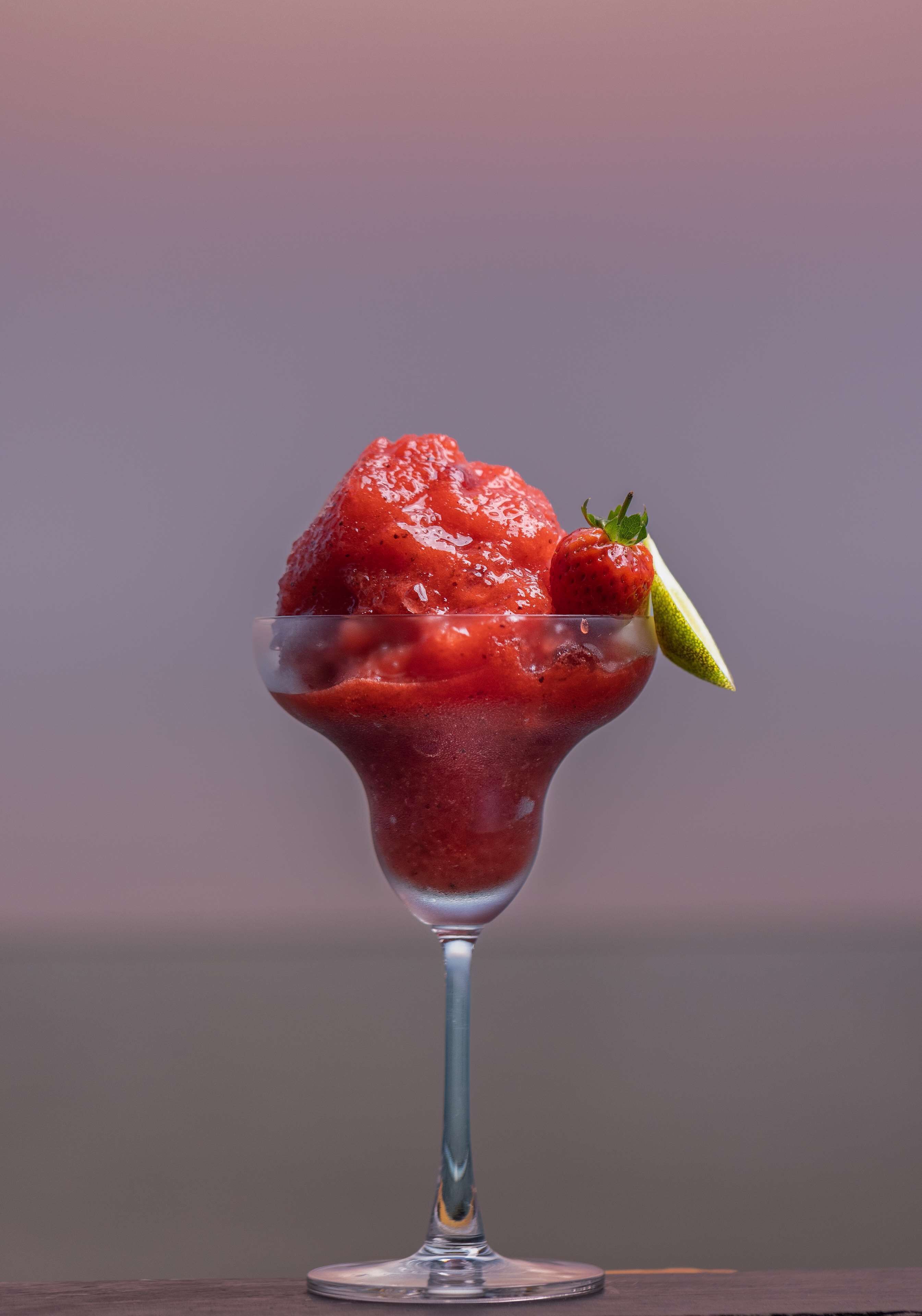 Un dessert servi dans un verre, décoré de fraises.