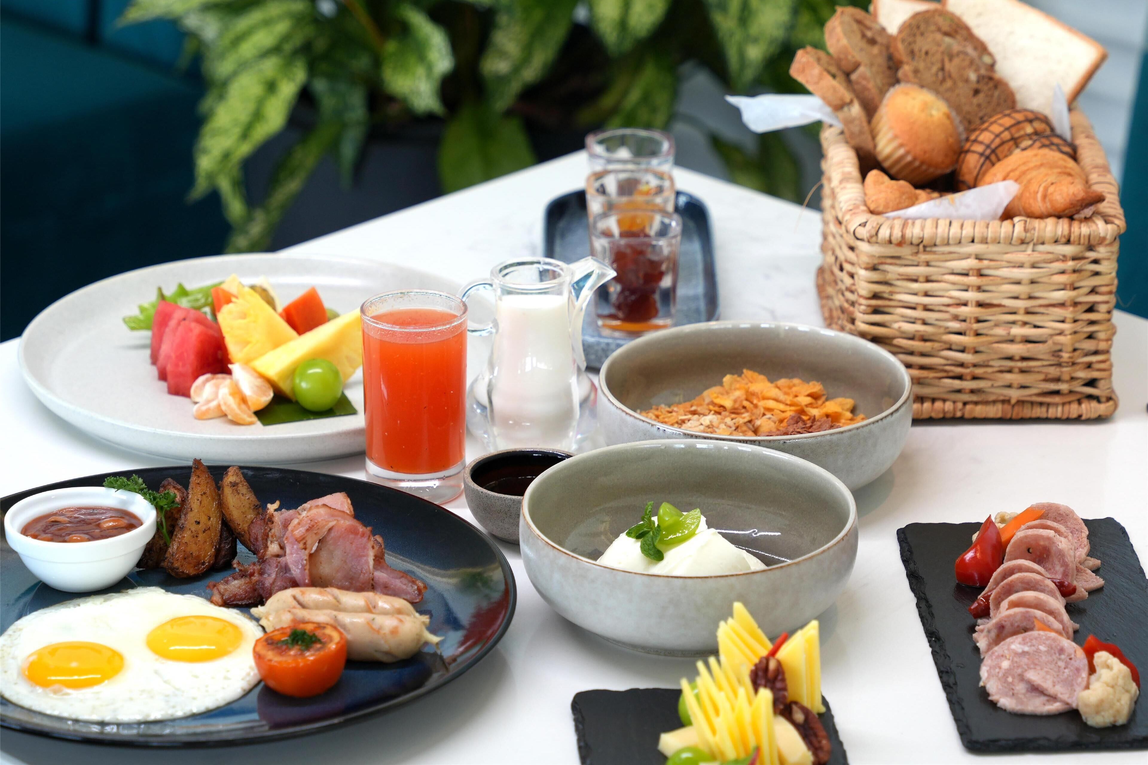 A breakfast spread with various dishes including eggs, bacon, toast, and pastries.