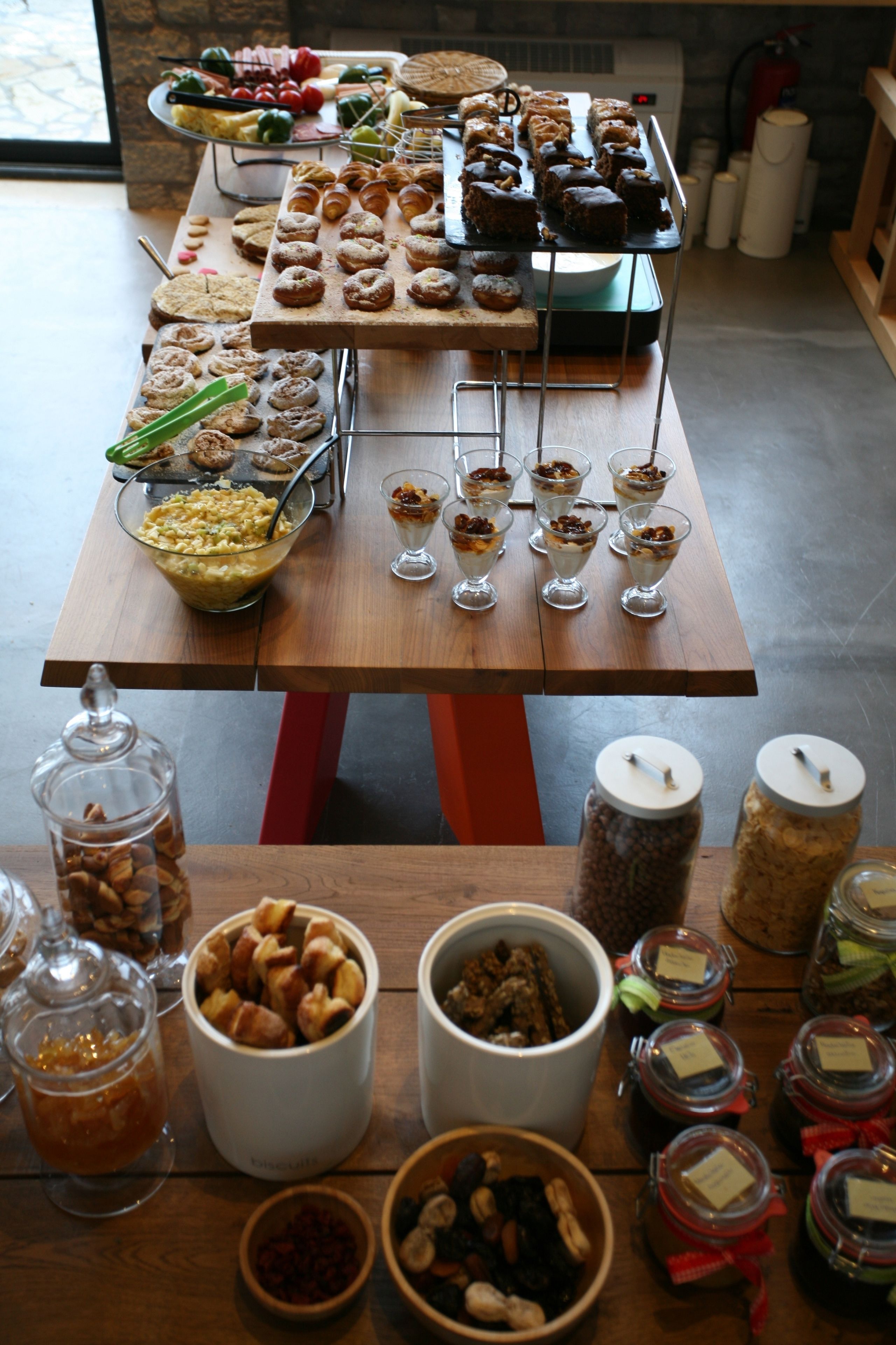 A buffet table with various food items and desserts.