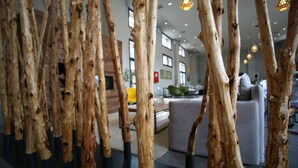 Um interior moderno com colunas altas e imitação de madeira, e uma área de estar acolhedora com um sofá e uma mesa de centro.