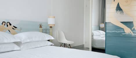 Un dormitorio moderno con una cama grande, una silla blanca y un mural en la pared.