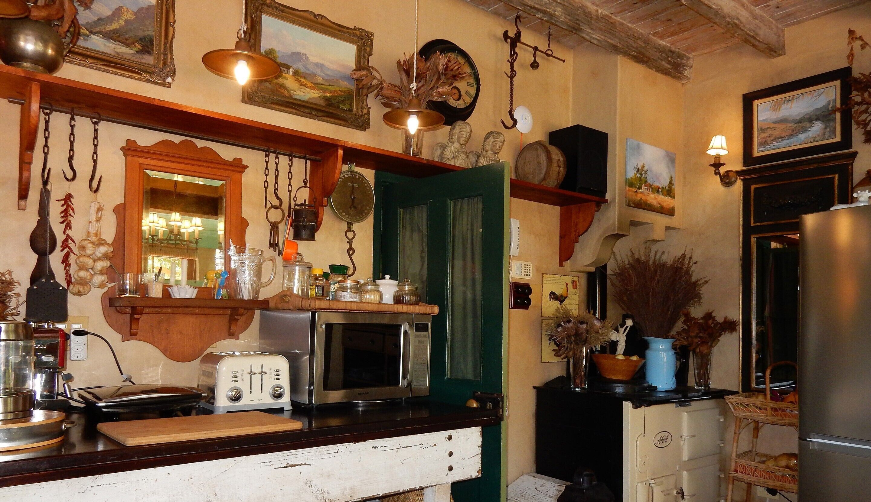 Una cocina con mostrador de madera, un tostador antiguo, un microondas y diferentes utensilios de cocina.