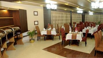 A restaurant with multiple tables, chairs, and a buffet area.