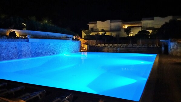 Piscina a l'aire lliure de temporada, para-sols i gandules