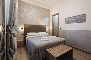 Una camera da letto ordinata con un letto, comodini, una panca e un'opera d'arte appesa al muro.