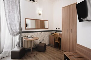 Un bagno moderno con una cassettiera, uno specchio e un televisore fissato alla parete.