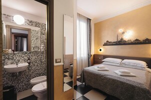 Una habitación de hotel con piso de cuadros, una cama con toallas, un lavamanos y un espejo.