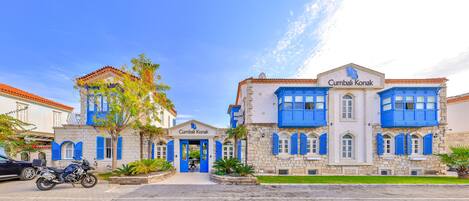 Ein Gebäude mit einer Stein-Fassade und blauen Fensterläden, genannt 'Cumbali Konak'.