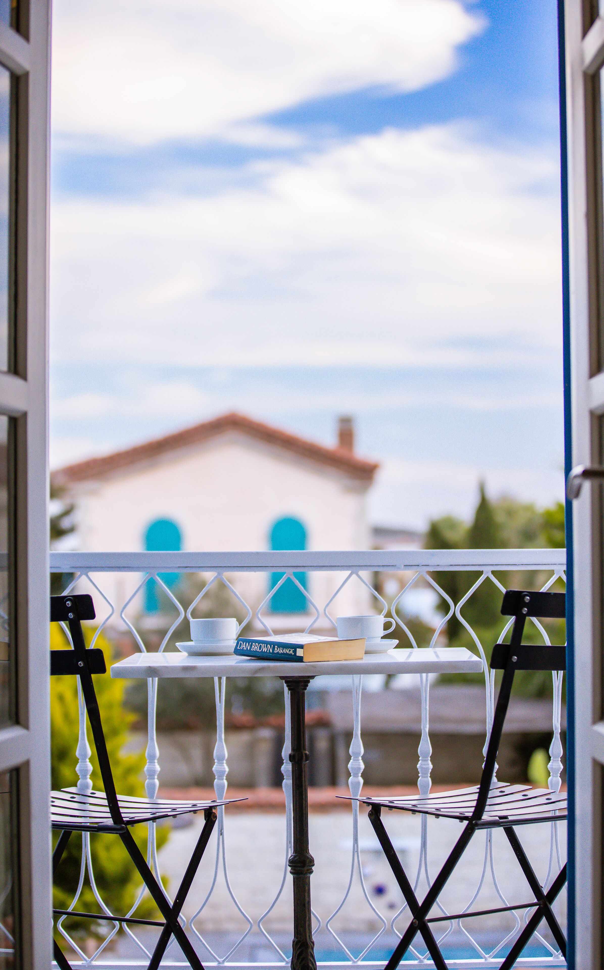 A balcony with a table, a book, and a cup.