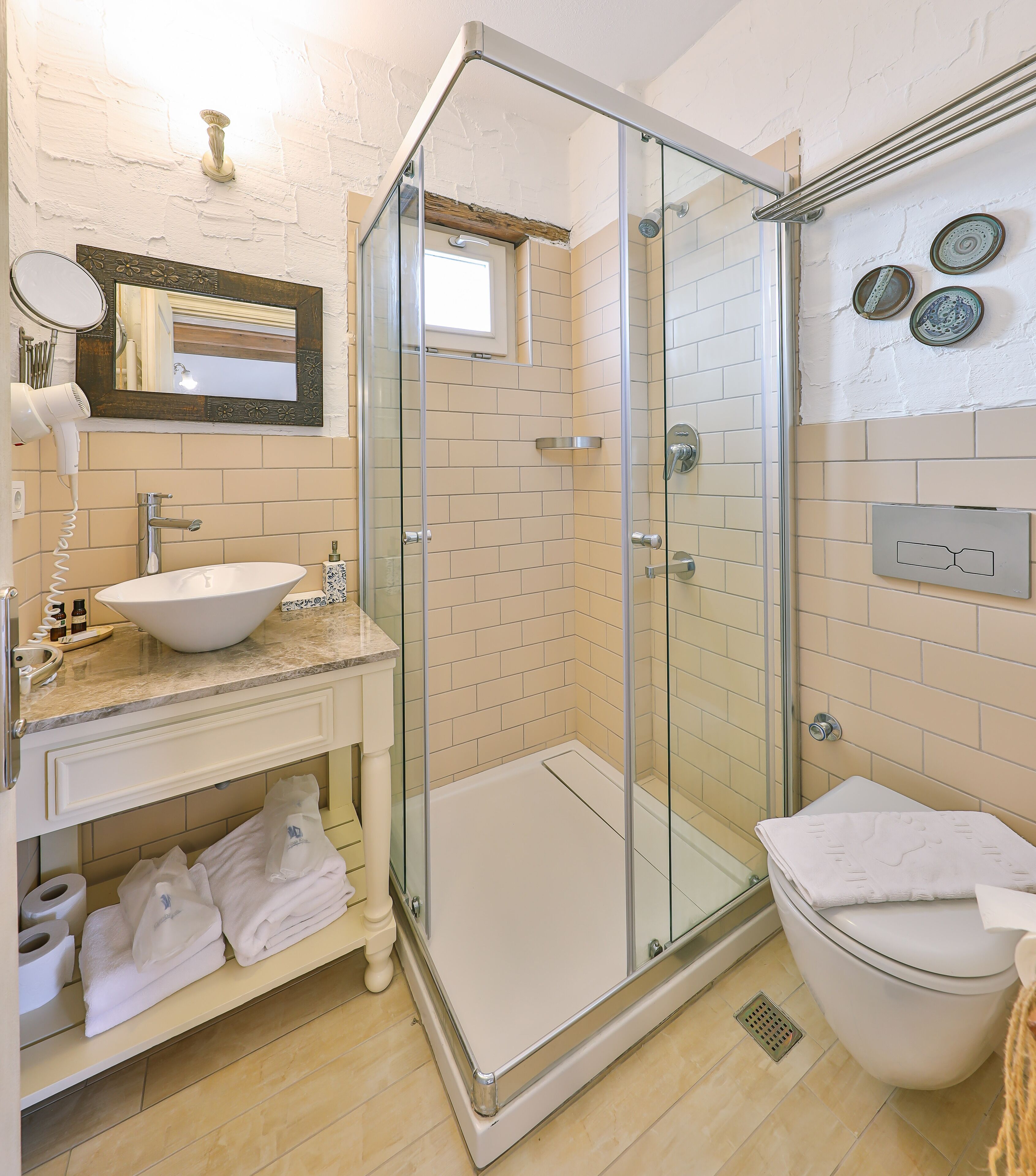 A modern bathroom with a glass-enclosed shower, a sink with a mirror above it, and a toilet.
