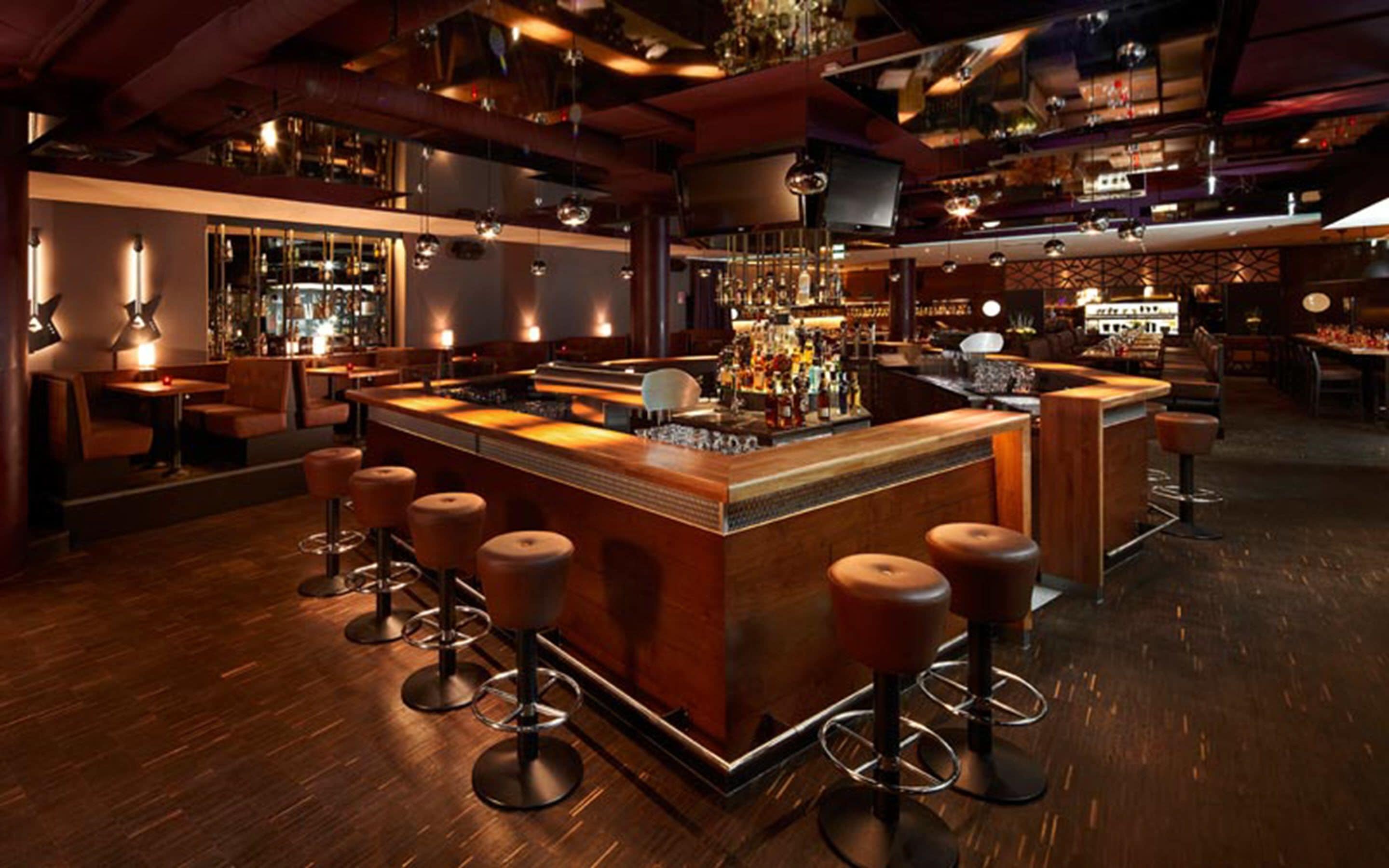 A bar with a central island, stools, and a bar counter.