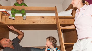 Cozy space for multiple guests, featuring a lower and upper bunk, bedside table, and lamp.