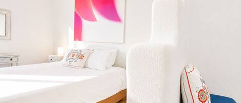 A hotel room with a bed, a nightstand, and a large abstract painting on the wall.