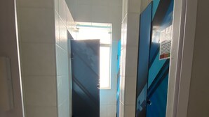 A narrow hallway with tiled walls and a tiled floor, leading to a room with a window. - Nomade In Arte e Hostel São Paulo (São Paulo)