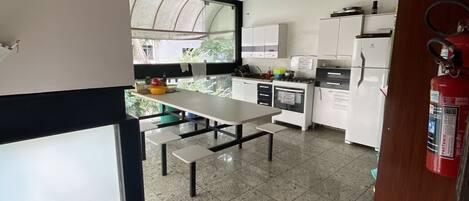 A modern kitchen with white cabinets, a large window, and a tiled floor.