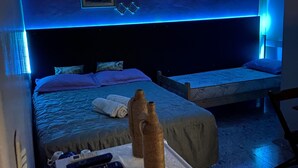 A hotel room with a bed, bedside table, and a small seating area. - Nomade In Arte e Hostel São Paulo (São Paulo)
