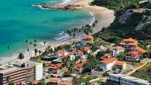 Una zona costiera con spiaggia, case e una scogliera.