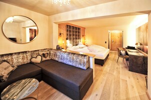 Una habitación de hotel moderna con una cama grande, un sofá, un escritorio y un espejo.