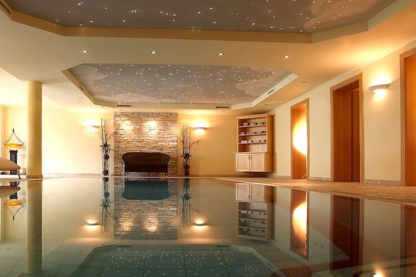 Una piscina techada, sillones reclinables de piscina