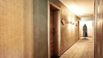 Un pasillo con puertas de madera y suelo alfombrado.