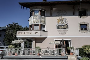 A building with a sign reading 'WELLNESS SPA' and a mural depicting a knight on horseback. - Die Seefelderin - Boutiquehotel St. Georg (Seefeld in Tirol)