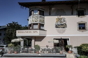 Un edificio con un letrero que dice 'WELLNESS SPA' y un mural que representa a un caballero a caballo.
