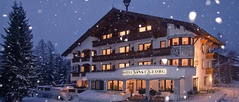 Vista frontal de la propiedad por la tarde o noche