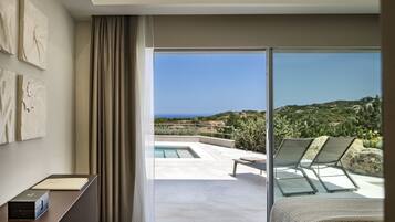 Una habitación de hotel moderna con un amplio ventanal corredero que da a una zona de piscina con vistas al océano.