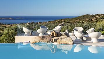 2 buitenzwembaden, een infinitypool en parasols bij het zwembad