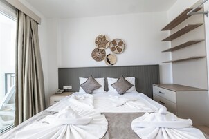 Una habitación de hotel con una cama bien hecha, una mesita de noche con teléfono y una pared decorada con arte mural.