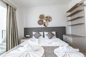 A hotel room with a neatly made bed, a bedside table with a phone, and a wall with decorative wall art.