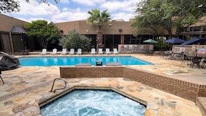 A hot tub with a brick surround, a swimming pool, lounge chairs, and umbrellas. - MCM Elegante Hotel and Conference Center Odessa (Odessa)