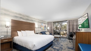 A modern hotel room with a large bed, a desk, a chair, and a view of the outdoors. - MCM Elegante Hotel and Conference Center Odessa (Odessa)
