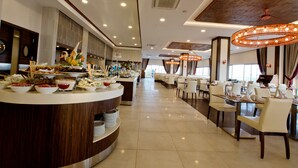 A spacious hotel dining area with a buffet counter, multiple dining tables, and modern lighting fixtures. - Ulu Resort Hotel - All Inclusive (Gülnar)