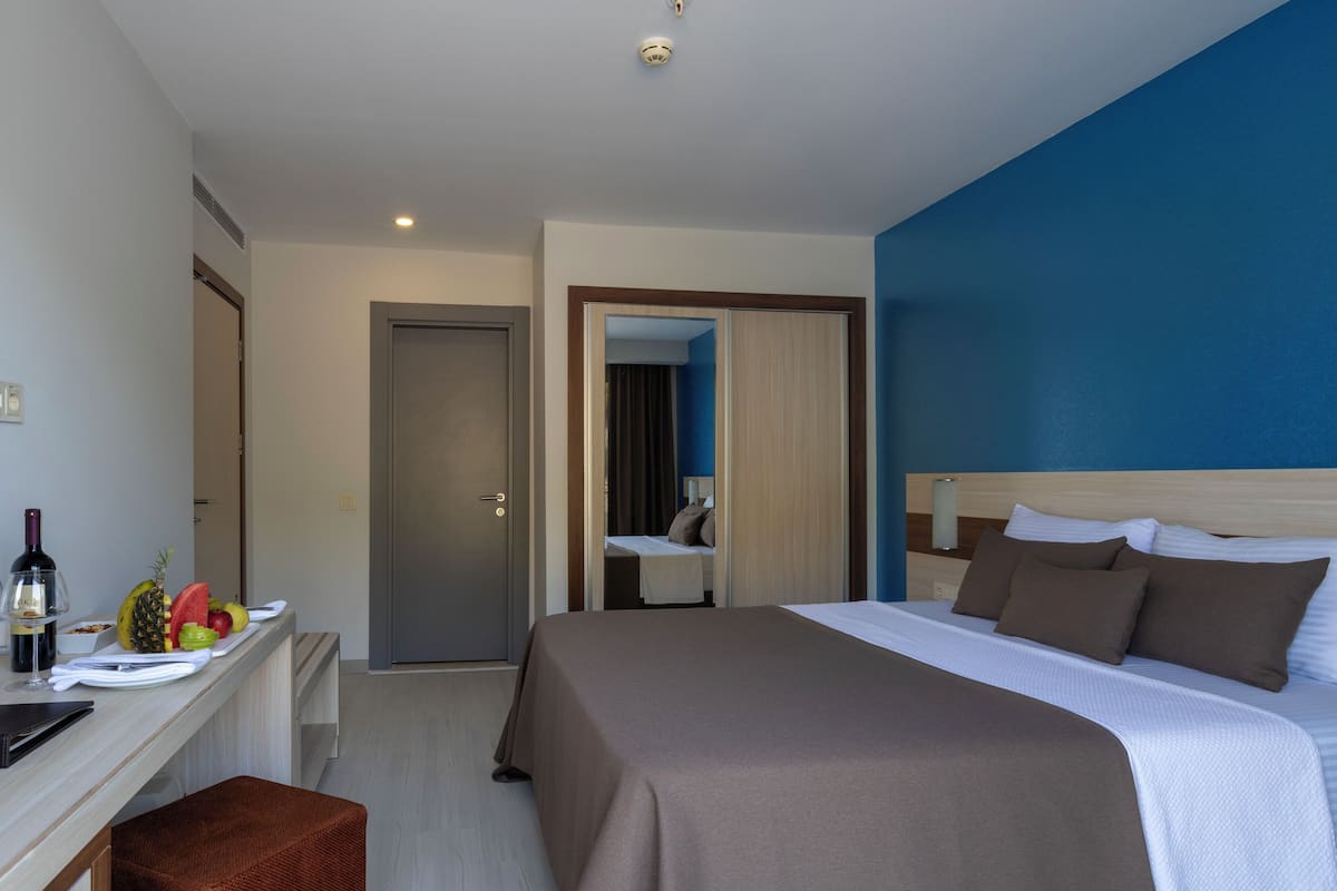 JUNIOR SUIT GROUND FLOOR | 1 slaapkamer, een minibar, een kluis op de kamer, een bureau