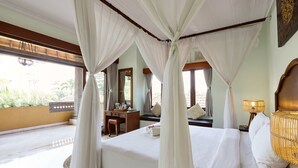 Quarto com uma cama grande, uma escrivaninha e uma cadeira.