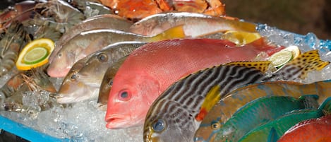 A variety of seafood on ice, including fish and lobsters.