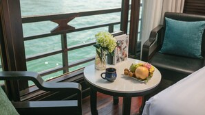 Un comedor con una mesa dispuesta para dos personas, un jarrón de flores y un menú.