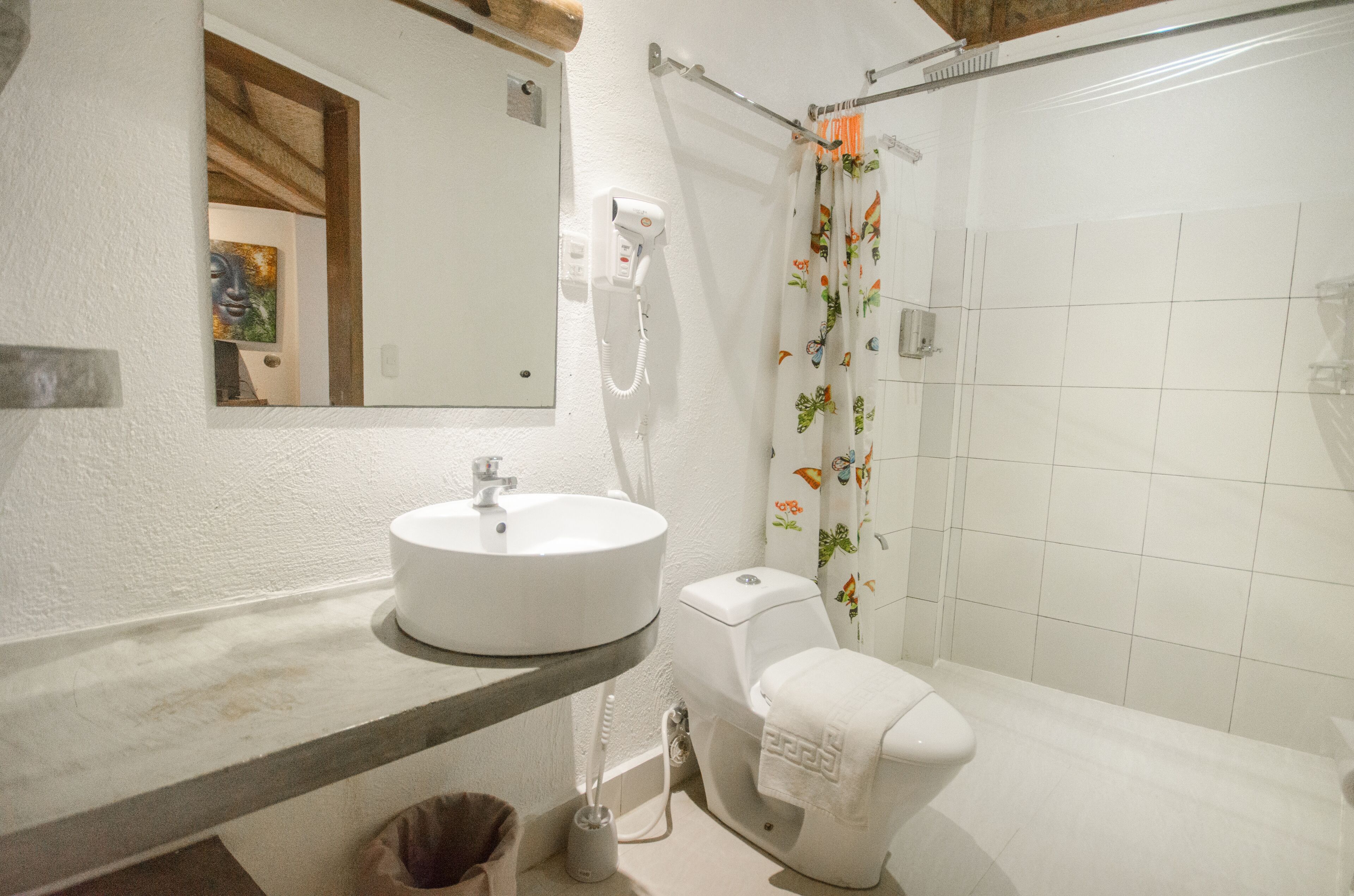 A bathroom with a white sink, toilet, and shower curtain with floral patterns.