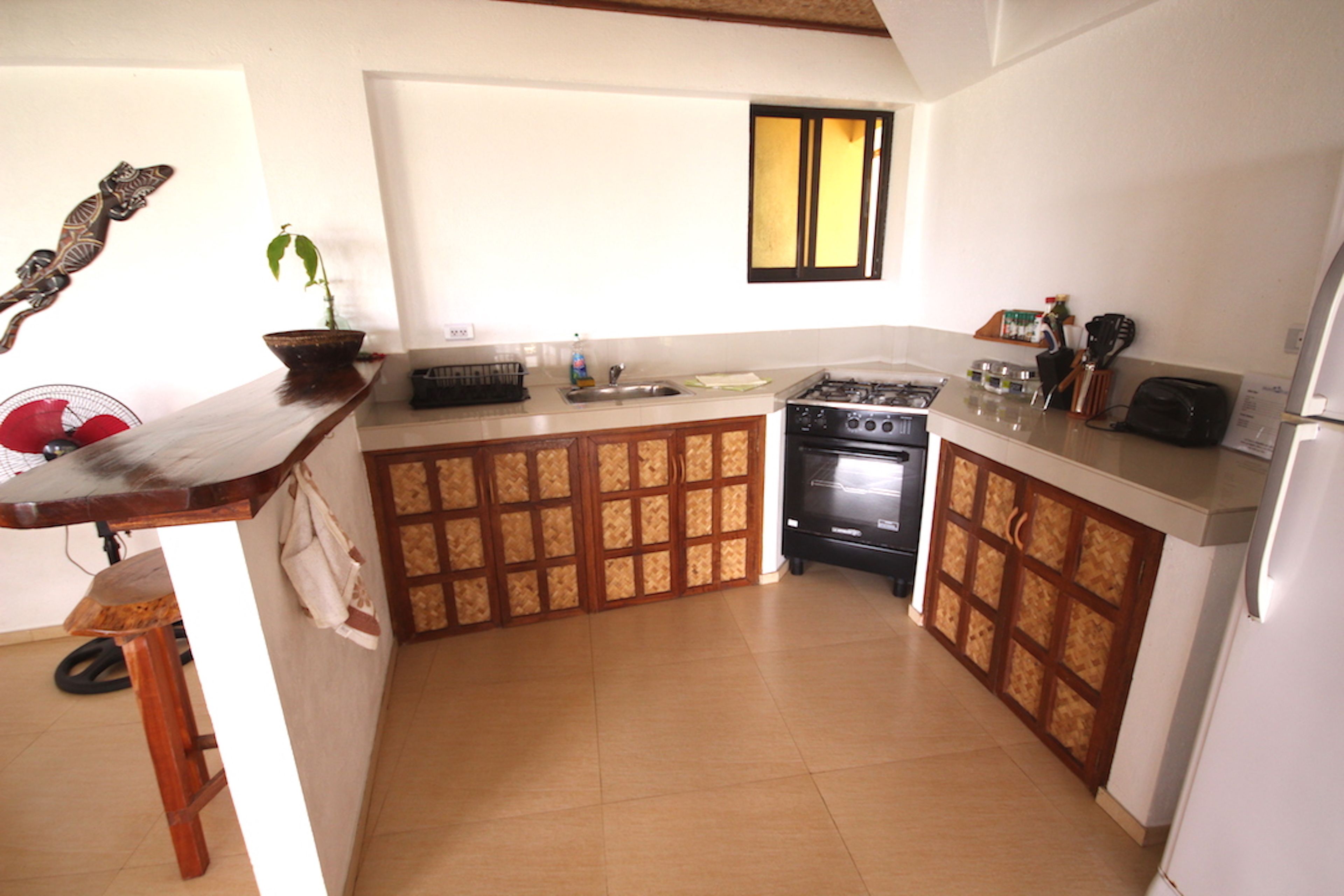 A kitchen with a stove, sink, and cabinets.