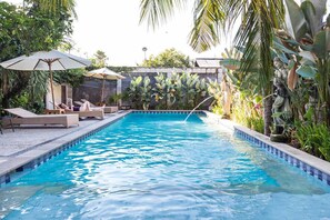 室外游泳池，池畔遮阳伞，日光浴躺椅