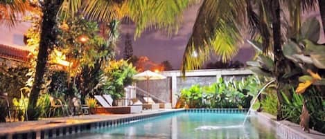 Alberca al aire libre, sombrillas en la alberca y camastros