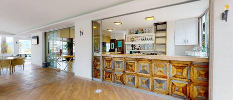 Un hall de hotel espacioso con suelo de madera, una recepción y vistas al exterior.