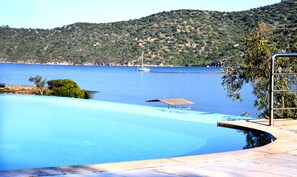 A swimming pool with a view of a body of water and a hilly landscape in the background. - Yalıçapkını Boutique Hotel - Boutique Class (Milas)