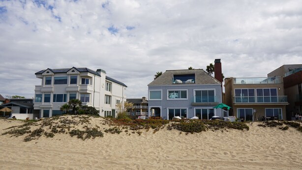 A beachfront property with a two-story house featuring a balcony and a flat roof. - Ocean Surf Inn & Suites (Huntington Beach)